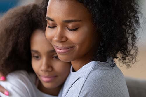 woman hugging her daughter with peace of mind after learning about camp worth