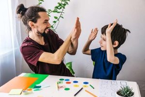 a father and his son with autism celebrate after successful completion of an autism spectrum disorder therapy program